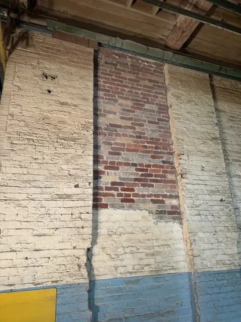 Dustless sandblasting removing old paint from a Toronto brick wall
