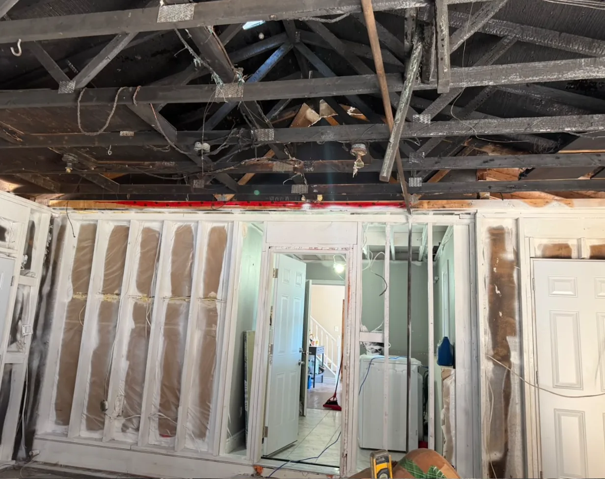 Fire-charred roof trusses above wall framing already dry ice blasted and sealed white during a GTA fire restoration