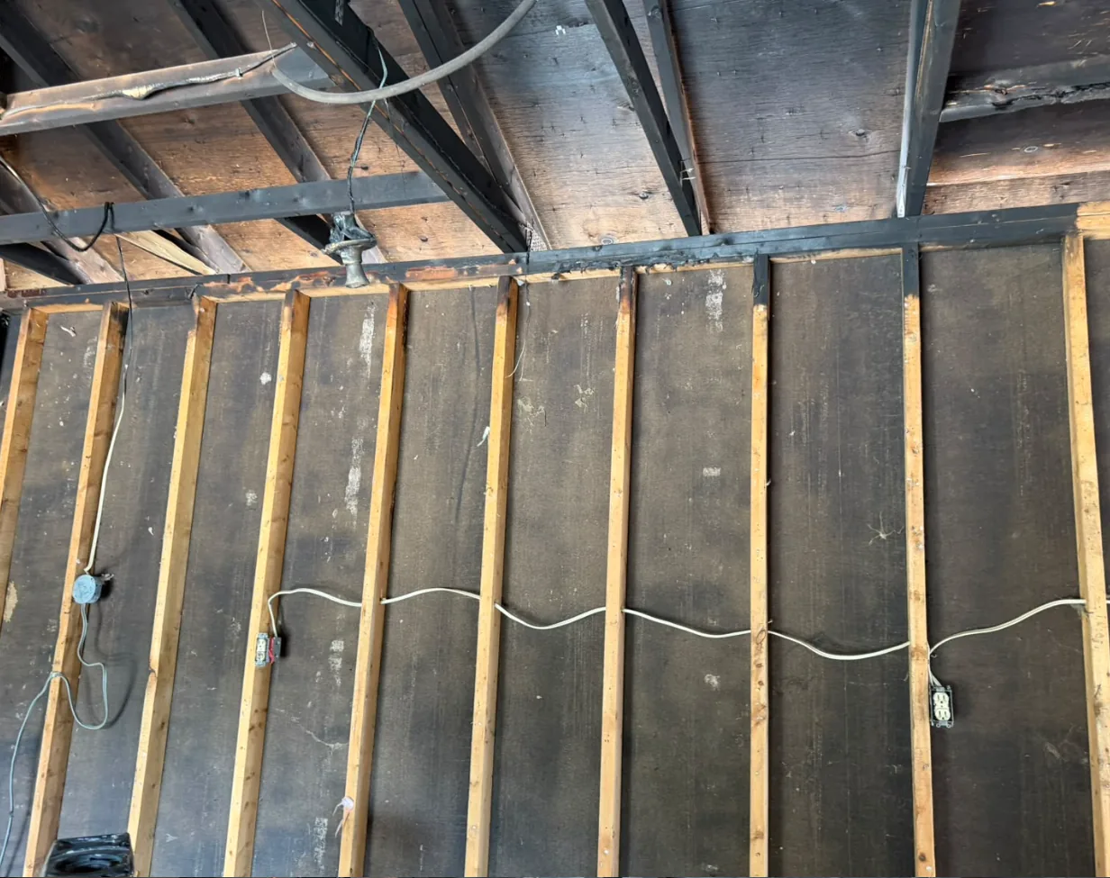 Soot-blackened wall sheathing and framing before dry ice blasting in a fire-damaged GTA home