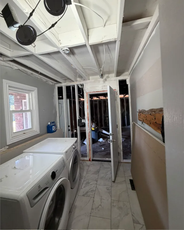 Laundry room ceiling structure cleaned and sealed after dry ice smoke damage restoration, ready for drywall
