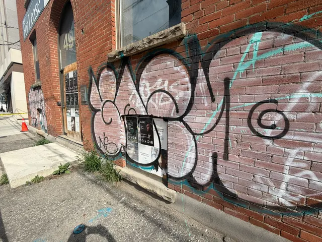 Graffiti-covered brick before exterior cleaning